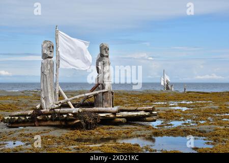 SAINTE-FLAVIE, QUEBEC, KANADA – 6. August 2023 – Gaspesie Art Center mit Holzfiguren auf einem Holzfloß mit weißer Flagge auf Saint-Lawrence Stockfoto