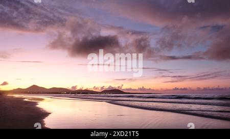 Ein wunderschöner Sonnenuntergang über dem Meer der Himmel ist voller Wolken, die eine ruhige und friedliche Atmosphäre schaffen. Stockfoto