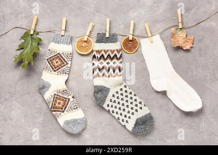 Schöne Komposition mit warmen Socken und Kleidernadeln auf grauem Hintergrund Stockfoto