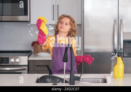 Wasch- und Reinigungskonzept. Kinder waschen und abwischen Geschirr in der Küche. Amerikanisches Kind lernt Hausarbeit zu Hause. Kinderreinigung, um Eltern zu helfen Stockfoto