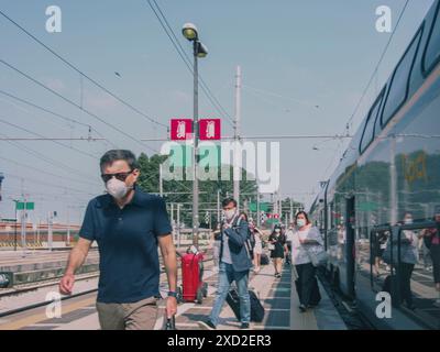 Venedig, Italien - 20. Juni 2020 Menschen, die soziale Distanz beobachten und Gesichtsmasken tragen, während sie am Bahnhof auf einen Zug warten Stockfoto