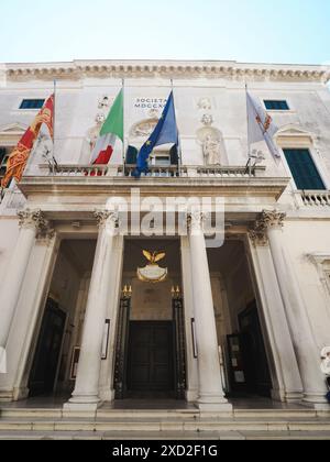 Venedig, Italien - 20. Juni 2023 wunderschönes venezianisches La Fenice Theater mit Fahnen italiens und der europäischen union an einem hellen und sonnigen Tag Stockfoto