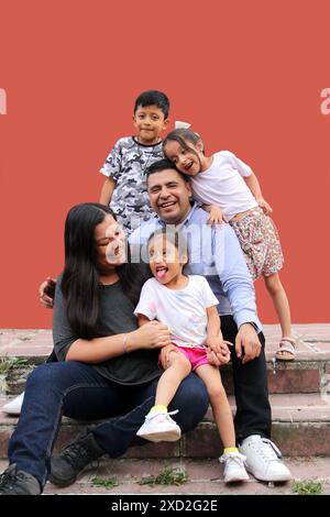 Familie von dunkelhäutigen Latino Mutter, Vater, Sohn und Töchter, die glücklich und gesund aussehen, um ihren Tag zu feiern Stockfoto