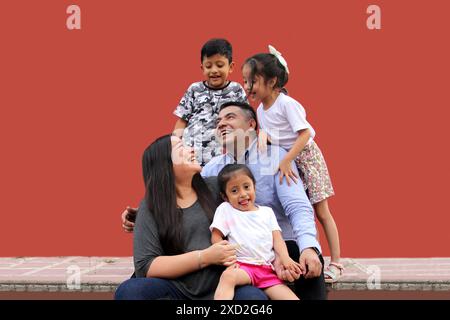 Familie von dunkelhäutigen Latino Mutter, Vater, Sohn und Töchter, die glücklich und gesund aussehen, um ihren Tag zu feiern Stockfoto