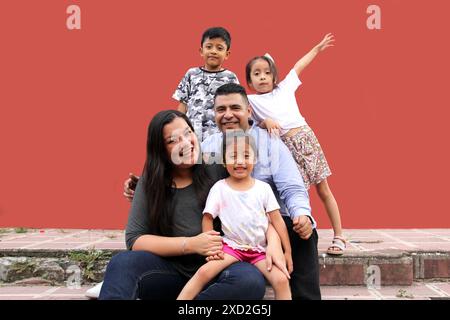 Familie von dunkelhäutigen Latino Mutter, Vater, Sohn und Töchter, die glücklich und gesund aussehen, um ihren Tag zu feiern Stockfoto