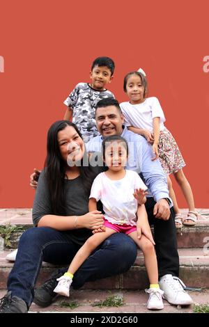 Familie von dunkelhäutigen Latino Mutter, Vater, Sohn und Töchter, die glücklich und gesund aussehen, um ihren Tag zu feiern Stockfoto