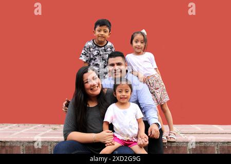 Familie von dunkelhäutigen Latino Mutter, Vater, Sohn und Töchter, die glücklich und gesund aussehen, um ihren Tag zu feiern Stockfoto