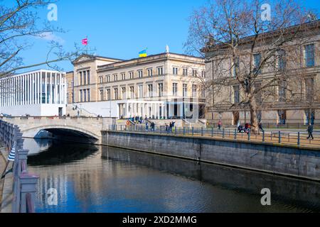 Der Himmel über dem Neuen Museum ist klar und die Besucher spazieren am Ufer in Berlin. Stockfoto