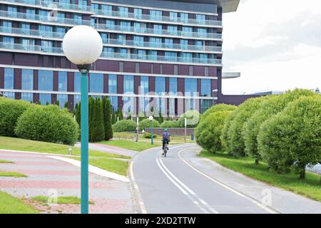 Anonym fährt Fahrrad auf dem Weg. Sport und Erholung in der Stadt im Sommer. Natur und Gesundheit. Stockfoto