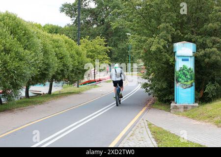 Anonym fährt Fahrrad auf dem Weg. Sport und Erholung in der Stadt im Sommer. Natur und Gesundheit. Stockfoto