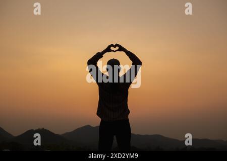 Ein junger Mann benutzt Gebärdensprache, um seine Liebe und Freundschaft zu seinem Freund und Liebhaber auszudrücken. Das Konzept der Gebärdensprache zeigt ein Herzsymbol, um Liebe auszudrücken, f Stockfoto