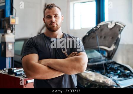 Techniker, Mann und Arme in der Garage für Autoreparatur, Service oder Sicherheit im Hochformat. Mechaniker, Person und kleines Unternehmen für das Fahrzeug Stockfoto