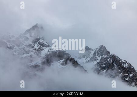 Schneebedeckte Berggipfel in Wolken Stockfoto