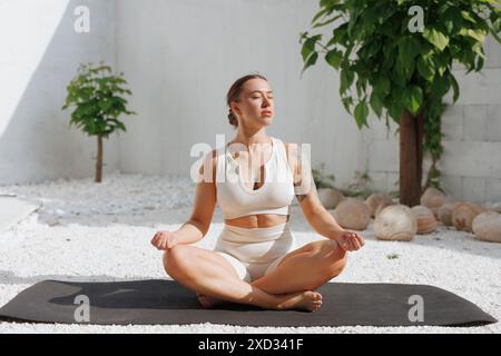 Yoga dehnt sich im Freien aus. Seitenansicht einer übergewichtigen Frau, die Yoga auf weißem Hintergrund übt, Körperpflegekonzept, Kampf gegen Übergewicht, Gewicht zu verlieren Stockfoto