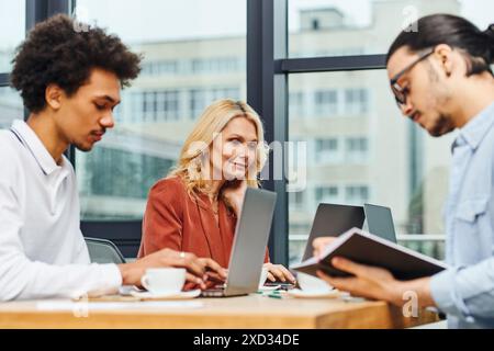 Arbeitssuchende konzentrieren sich während des Gruppengesprächs am runden Tisch auf Laptops. Stockfoto