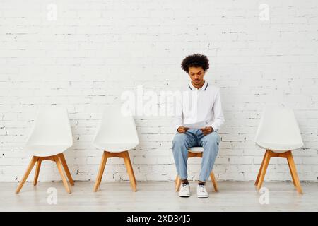 Mann umgeben von weißen Stühlen in einer künstlerischen Darstellung der Einsamkeit. Stockfoto