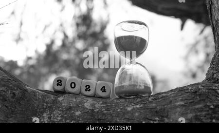 Schwarzweißbild mit quadratischen Würfeln, die mit Sanduhrglas geformt sind, und Text von 2024. Das Ende des Jahres 2024 Stockfoto