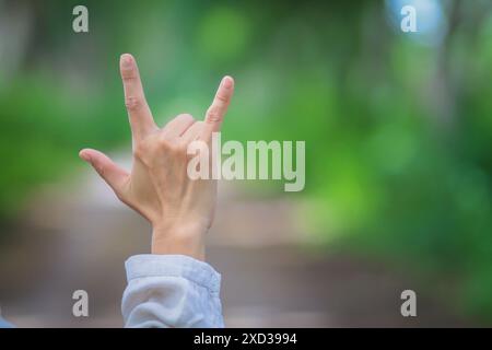 Der Mann benutzt Gebärdensprache Ich liebe dich, um seine Liebe und Freundschaft auszudrücken, seinen Freund und Geliebten. Gebärdensprache, die das Symbol „Ich liebe dich“ zeigt, um die Liebe f auszudrücken Stockfoto