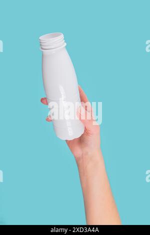 Die Hand der Frau hält weiße Plastikflasche Stockfoto