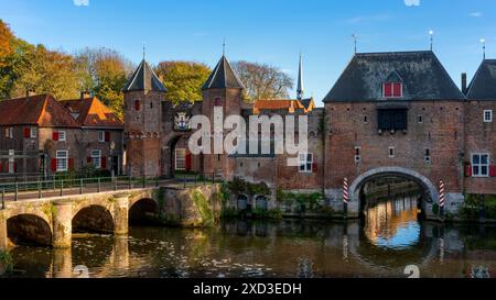 Das berühmte mittelalterliche Tor Koppelpoort, zusammen mit den traditionellen rot-weißen Fensterläden und alten Steinbögen spiegeln sich über die Ruhe Stockfoto
