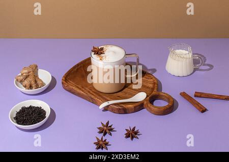 Von oben köstlicher Chai Latte mit cremigem Schaum, auf einem Holzbrett vor farbenfroher Kulisse Stockfoto