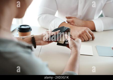 Hände-, Stoff- und Ledermuster mit Personen zur Diskussion über den Fahrzeuginnenraum zum Kauf im Händlerbetrieb. Material, Verkäufer und weibliche Kundin mit Stockfoto