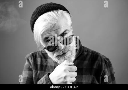 Ein Mann, der raucht. Nahgesicht eines jungen Mannes ohne Gefühle. Porträt gut aussehender Geschäftsmann mit selbstbewusstem Gesicht Stockfoto