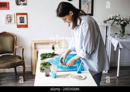 Eine Künstlerin, die in ihrem Studio eine Epoxidharzlandschaft herstellt Stockfoto