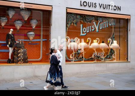 Am 9. Juni 2024 in London, Großbritannien, passieren die Menschen die Flamingofenster vor der Ladenfront von Louis Vuitton in der Bond Street. Bond Street ist eine der wichtigsten Straßen im West End Einkaufsviertel und ist sehr hochwertig. Es ist seit dem 18. Jahrhundert eine modische Einkaufsstraße. Das reiche und wohlhabende Geschäft hier ist hauptsächlich für High-End Mode und Schmuck. Stockfoto