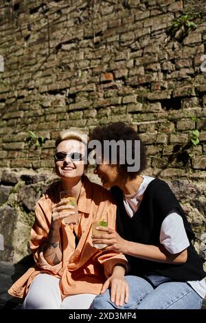 Ein vielfältiges Paar von Frauen sitzt eng zusammen in einem Café und genießt die Gesellschaft. Stockfoto