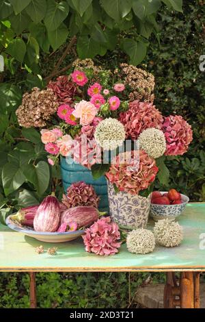 Botanik, Hortensie, allium, Rosen und Kallistephus in Töpfervasen auf einem grünen Holztisch im Freien, EXTRA-RIGHTS-CLEARANCE-INFO-NOT-AVAILABLE Stockfoto