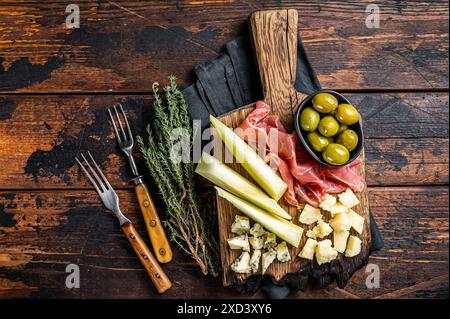 Käse- und Fleischplatte, Antipasti mit Prosciutto-Schinken, Parmesan, Blauschimmelkäse, Melone und Oliven auf Holzbrett. Holzhintergrund. Draufsicht. Stockfoto