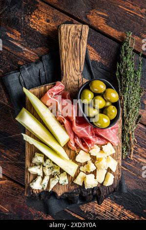 Käse- und Fleischplatte, Antipasti mit Prosciutto-Schinken, Parmesan, Blauschimmelkäse, Melone und Oliven auf Holzbrett. Holzhintergrund. Draufsicht. Stockfoto