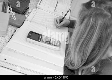 Kaukasisches Teenager Mädchen konzentrierte sich auf Mathe-Hausaufgaben zu Hause in den USA. Stockfoto