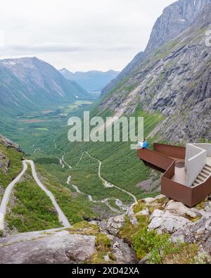 Ein Paar genießt den Panoramablick von einem malerischen Ausblick in Norways majestätisches Bergtal. Die gewundene Straße führt durch üppige grüne Landschaften und dramatische Klippen. Trollstigen Road Norwegen Stockfoto