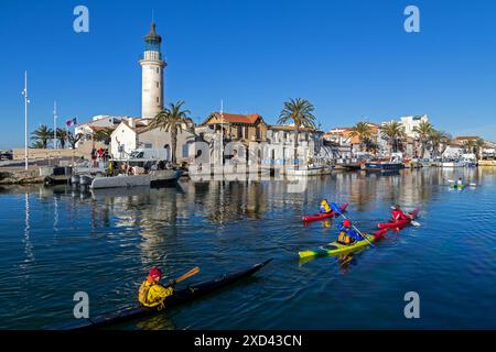 Passage de Kayaks de mer devant le phare à l'entrée du Port du Grau-du-ROI vor dem Leuchtturm am Eingang zum Hafen von Grau-du-ROI. Occitanie, Frankreich Stockfoto