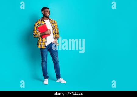 Foto eines netten, fröhlichen jungen Mannes tragen trendige karierte Kleidung, die leeren Raum isoliert auf cyanfarbenem Hintergrund steht Stockfoto