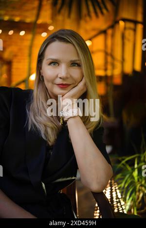 Abends im Freien Porträt einer ruhigen und positiven Frau mittleren Alters, die auf der Außenterrasse sitzt Stockfoto