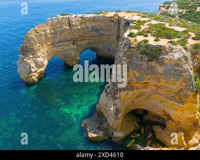 Große Felsformationen mit natürlichen Bögen an der Küste, in der Nähe des Wassers mit Kanus, Blick aus der Luft, Praia da Marinha, doppelter Felsbogen, Lagoa, Felsig Stockfoto