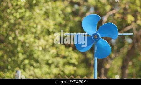 Eine blaue Flügelfahne dreht sich im Sommer im Wind. Stockfoto