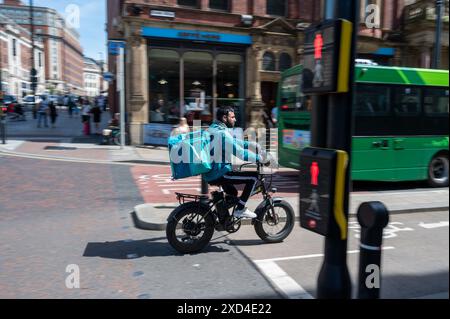 Fahrradfahrer, der an einem warmen Sommertag im Zentrum von Leeds ein E-Bike auf einem Radweg fährt Stockfoto