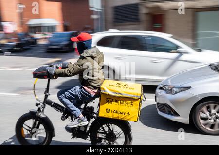 An einem warmen Sommertag fährt ein Fahrradfahrer mit einem E-Bike durch das Zentrum von Leeds Stockfoto