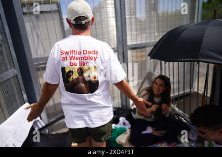 Brian Wood, ein Fan von Taylor Swift aus den Vereinigten Staaten, zeigt die Rückseite seines T-Shirts, während er in der Red Zone den VIP-Eingang zum Wembley Stadium in London wartet, vor Taylor Swifts erstem Konzert in London während der Eras Tour. Bilddatum: Donnerstag, 20. Juni 2024. Stockfoto