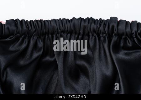 Schwarzes seidiges Tuch mit geschwungener Falz und weißem Kopierraum Stockfoto