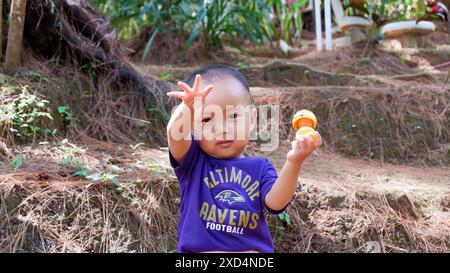 Foto eines 2-jährigen Kleinkindes lacht bei einer Tour durch den Kiefernwald in Wonosobo, 15. April 2019 Stockfoto