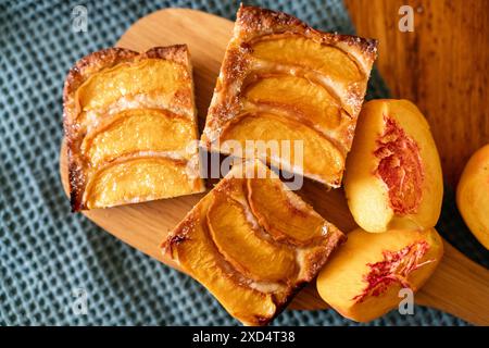 Ein Dessert aus geschnittenen Pfirsichen ist auf einem hölzernen Schneidebrett. Das Dessert ist mit Zucker bedeckt und sieht köstlich aus. Stockfoto