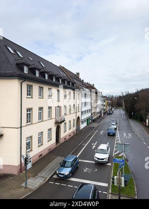 Freiburg im Breisgau, Deutschland - 6. März 2024: Eine erhöhte Luftaufnahme einer Straßenkreuzung in Freiburg im Breisgau, die Autos zeigt, welche Richtung sie einschlagen. Das Bild erfasst die dynamische städtische Umgebung und die Verkehrsbewegung Stockfoto