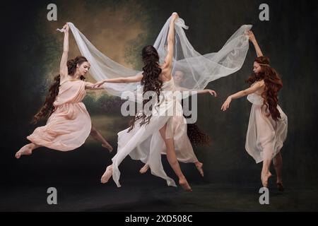 Eine Gruppe junger, schöner Ballerinas bewegt sich anmutig im Tanz, als Musen vor Vintage-Studio-Hintergrund. Stockfoto