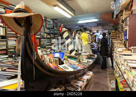 Das Innere der Libreria Acqua Alta mit Einkäufern, einem einzigartigen Buchladen mit Büchern in einer Gondel, Castello, Venedig, Italien, beliebt bei Touristen Stockfoto