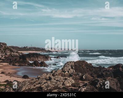 Sehen Sie, wie die Wellen des Atlantischen Ozeans auf dem großen felsigen Stein am wunderschönen Vulkanstrand portugals brechen Stockfoto